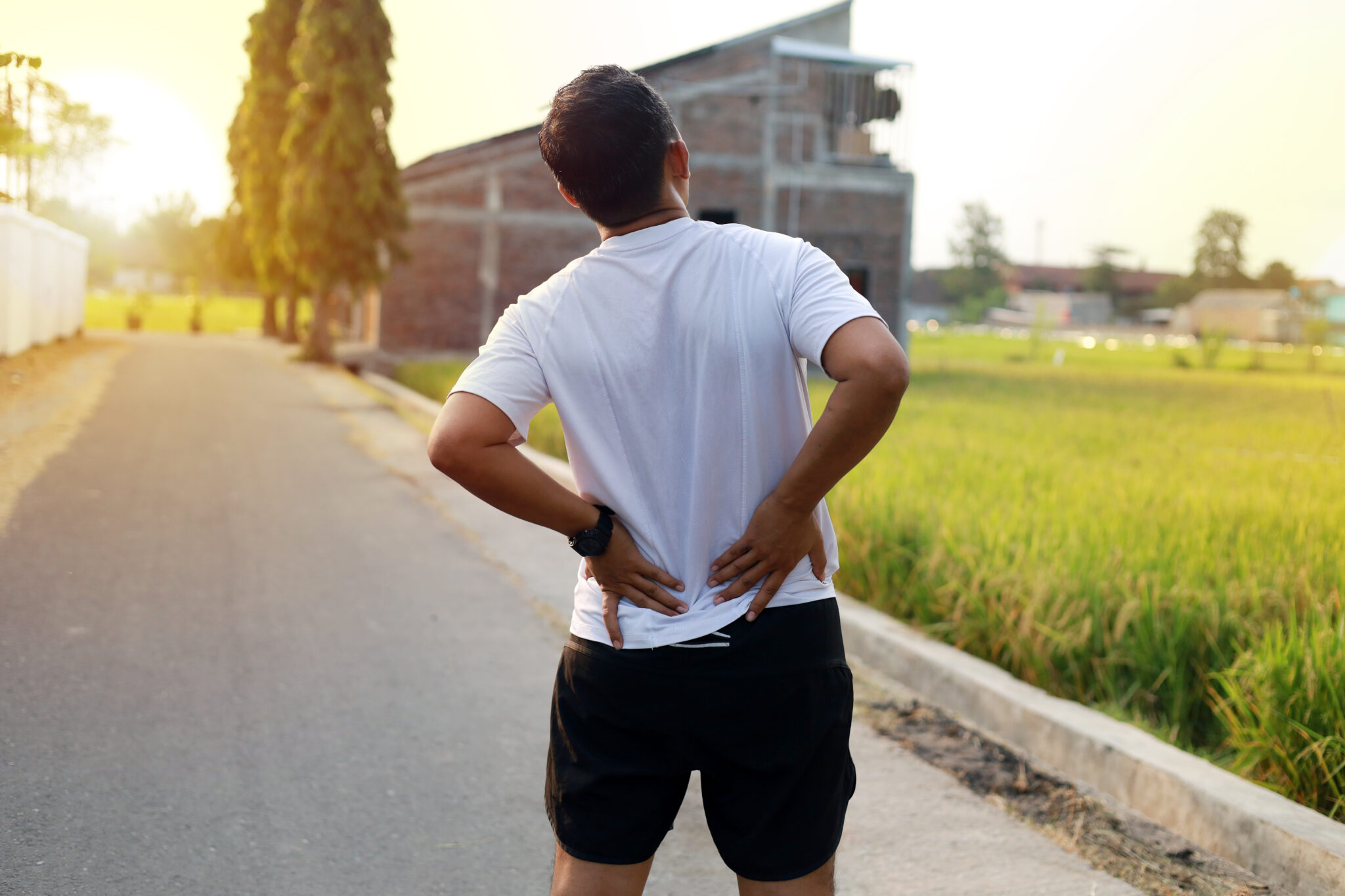 Man with back pain during doing outdoor exercise